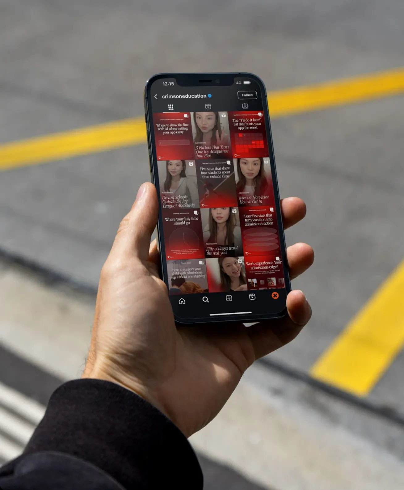 A phone held at a street crossing showing the Crimson Education Instagram profile, a grid of red carousel covers about essays, applications and acceptances