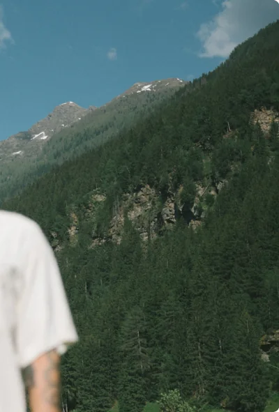 A figure in white against a forested slope