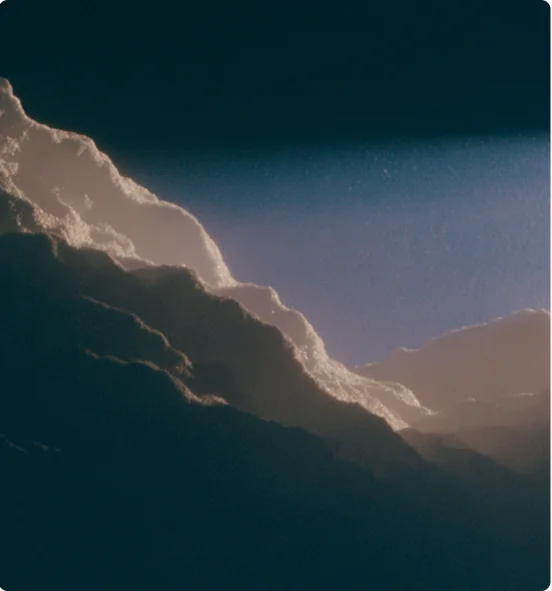 A dark ridge lit along its edge at dusk