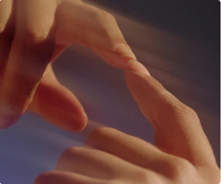 Fingers reaching across a lit surface